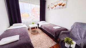 a room with two beds and a chair and a window at Oulu city center 4-room apartment Parking in Oulu