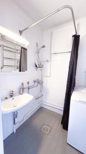 a white bathroom with a sink and a shower at Oulu city center 4-room apartment Parking in Oulu