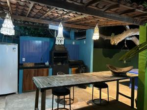 a kitchen with a wooden table and some lights at Casa MCAYA in Fortim