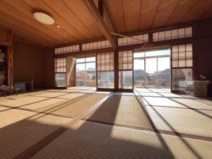 Una habitación vacía con grandes ventanas en un edificio. en 広い縁側とタタミの部屋に天井吹抜けのオープンキッチンがある一軒家でキッチンやバスルームは最新設備, en Komoro 79 fotos más