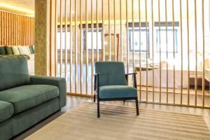 a living room with a chair and a couch at Fonte da Rosa Guest House Central Studio in Belmonte