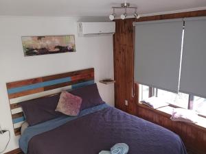 a bedroom with a bed with a wooden headboard and a window at Hostal La Casa del Puente in Santiago +64 photos