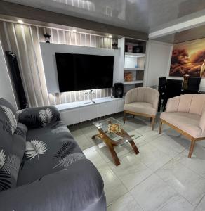 a living room with a couch and a flat screen tv at Bulevar Santa Rosa, apartamento nuevo y acogedor in Santa Rosa de Cabal