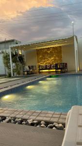 a swimming pool with two benches next to a house at تريت ان فيلا in Buraydah