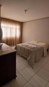 una camera da letto con un letto in una stanza con una finestra di Hospedaria Em Lagoa - Apto 102 - Residencial Cota a Lagoa da Prata