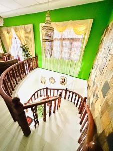 une pièce avec des murs verts et un escalier en bois dans l'établissement A Home Away B&B, à Kiribatkumbura
