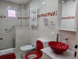 Un baño con un lavabo rojo y un inodoro. en Apart Ruta 40, en El Chaltén