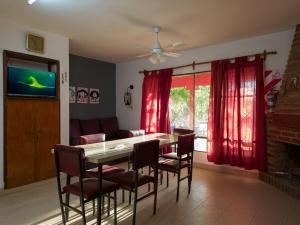 ein Esszimmer mit Tisch und Stühlen und einem Fernseher in der Unterkunft Alojamiento Arroyo de los Patos in Arroyo de Los Patos + 14 Fotos