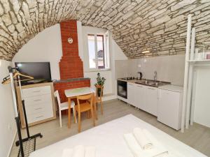 a kitchen and dining room with a brick wall at Studio Jokovi - Studio Apartment with Terrace and City View in Vela Luka +20 photos