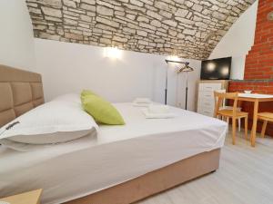 a bedroom with a bed and a dining room with a table at Studio Jokovi - Studio Apartment with Terrace and City View in Vela Luka