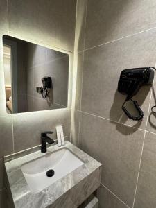 a bathroom with a sink and a phone on the wall at luxury apartment in Al-ʿUla