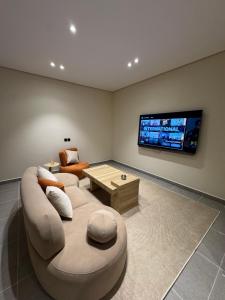 a living room with a couch and a tv at luxury apartment in Al-ʿUla