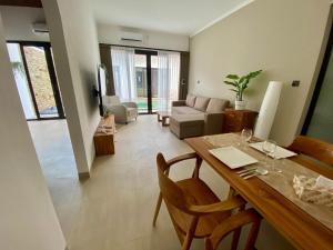 Una sala de estar con una mesa de comedor y un sofá. en Badung Villa no 4, en Ungasan