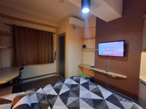 a room with a bed and a tv on a wall at Easton Park Residence Jatinangor - GIANDARA in Sayang