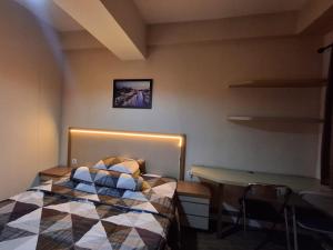 a bedroom with a bed and a table in it at Easton Park Residence Jatinangor - GIANDARA in Sayang +2 photos