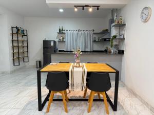 a dining room table with two chairs and a kitchen at Departamento en Zona Norte A ESTRENAR con hermosa vista in Salta
