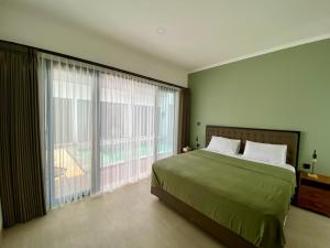 Un dormitorio con una cama grande y una ventana grande en Badung Villa no 4, en Ungasan