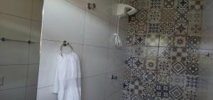 a bathroom with a shower with a white towel at Encanto Astral in São Thomé das Letras
