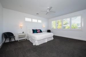 Un dormitorio blanco con una cama y una ventana. en Ocean Pearl - Oceanview Luxe Escape with Pool, en Tootgarook 23 fotos más