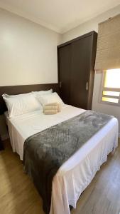 un grande letto bianco in una stanza con una finestra di Studio 360 MontBlanc a Brasilia