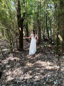 a woman in a white dress standing in a forest at Cabaña en la naturaleza in Puerto Montt