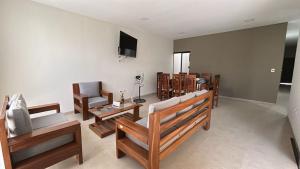 a living room with wooden furniture and a flat screen tv at Casa Manu in Trinidad
