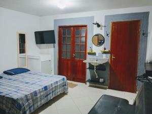 a bedroom with a bed and a red door at Karaguashouse in Florianópolis