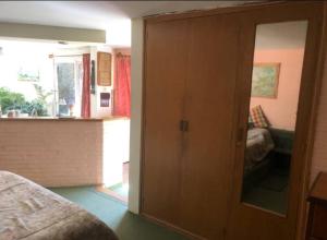 ein Schlafzimmer mit einem großen Holzschrank und einem Spiegel in der Unterkunft Cabaña Privada en Villa & Templo Jardín in La Paz