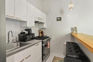 una cocina con fregadero y estufa horno superior en Perfectly Located 1 Bedroom I Uptown - Magazine St, en Nueva Orleans
