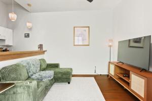 Una sala de estar con un sofá y un televisor. en Perfectly Located 1 Bedroom I Uptown - Magazine St, en Nueva Orleans