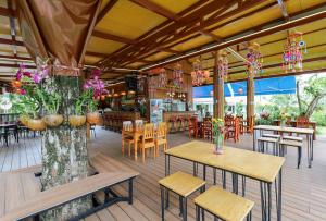an empty restaurant with tables and chairs and flowers at The Golddiggers Resort in Nai Yang Beach