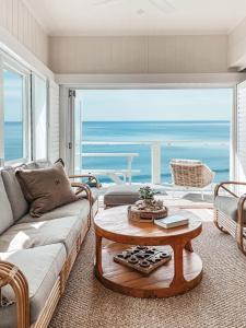 a living room with a couch and a table at Bay Properties The Beach House in Yamba +12 photos