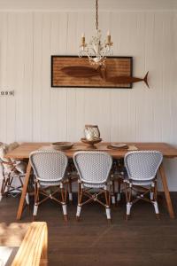 a dining room table with chairs and a chandelier at Bay Properties The Beach House in Yamba