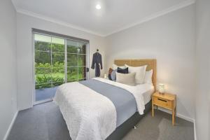 une chambre avec un grand lit et une fenêtre dans l'établissement Callala Bay & Beach House - Pet Friendly with Fireplace, à Callala Bay