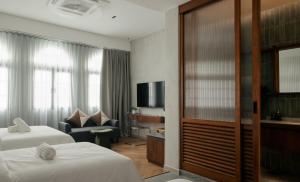 a hotel room with two beds and a television at Bishop House in George Town