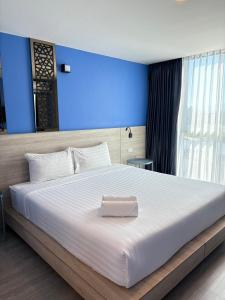 a bedroom with a large white bed with a blue wall at วัน บัดเจท เชียงราย สนามกีฬา One Budget Hotel Chiangrai Stadium in Chiang Rai +20 photos