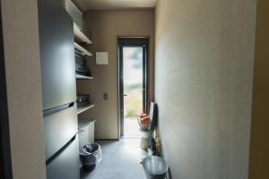 un pasillo con una puerta que da a una cocina con cubos de basura en COCO VILLA 湯布院-Yufuin-, en Yufu 132 fotos más