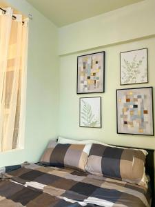 a bed in a bedroom with pictures on the wall at Cozy Cabin by JLS Near Venice Grand Canal Mall in Manila +9 photos