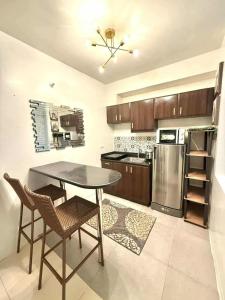 a kitchen with a table and chairs and a refrigerator at Cozy Cabin by JLS Near Venice Grand Canal Mall in Manila