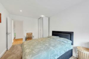 a bedroom with a large bed and a chair at Charming 1BD Flat with Parking in Bromley in Grove Park