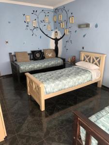 ein Schlafzimmer mit 2 Betten und eine Wand mit Bildern darauf in der Unterkunft Casa a 7 cuadras de la playa in Mar del Plata
