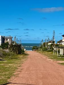 eine unbefestigte Straße neben einem Strand mit dem Meer in der Unterkunft Casitas Punta del Diablo in Punta Del Diablo