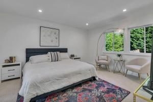 a bedroom with a bed and a chair and windows at Stylish Bellevue Retreat in Bellevue