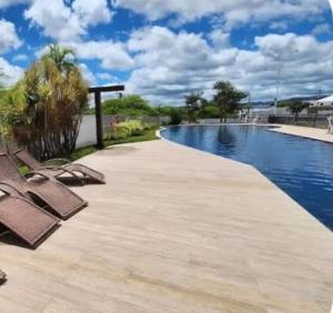 a swimming pool with two lounge chairs next to it at Studio 06 in Caruaru