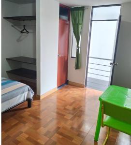 a room with a bed and a table and a door at BlancaWasi in Chiclayo