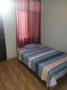 a bed in a room with a pink curtain at BlancaWasi in Chiclayo +15 photos