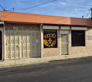 a building with a sign on the side of it at Velaz Guesthouse in Alajuela