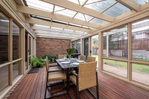 Un porche cubierto con una mesa y sillas. en Queens Beach Retreat - Beachside Coastal Escape, en Sorrento