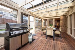 un patio al aire libre con parrilla y mesa en Queens Beach Retreat - Beachside Coastal Escape, en Sorrento