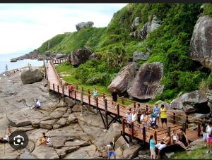 イタニャエンにあるCasa térrea com 2 quartos em Itanhaemの海岸の木造橋にいる人々のグループ